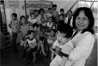 photo : Alexis Duclos. Mme la professeur Nguyen Thi Ngoc Phuong, 3 infirmières et le groupe d’enfants handicapés, victimes de l’Agent Orange, qui vivent à la maternité.