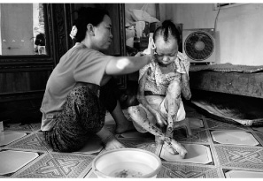 photo : Olivier Papegnies - Province de Quang Tri, Viêt Nam, 2006. Sans aide extérieure, Tram Van Tram, père de 7 enfants dont 4 handicapés, a créé un système ingénieux pour leur procurer une rééducation motrice.
