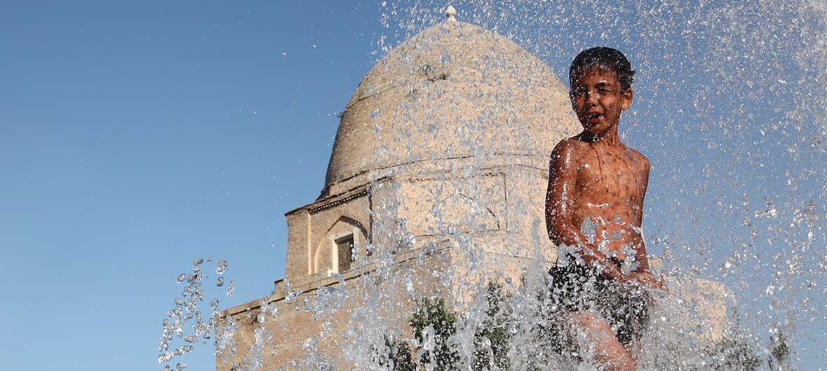 Un garçon de 11 ans se rafraichit de la chaleur estivale en jouant dans une fontaine dans un quartier historique de la ville de Samarkand, en Ouzbékistan.