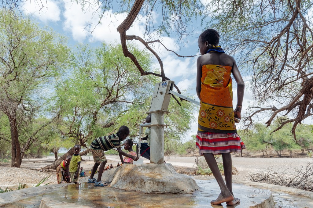 Des enfants utilisent une pompe à eau au Kenya.