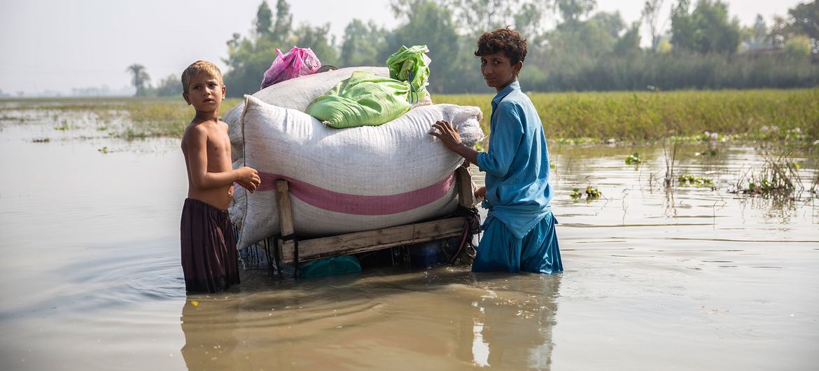 Des enfants rentrent chez eux à travers les eaux de crue contaminées à Jacobabad, dans la province du Sindh, au Pakistan.