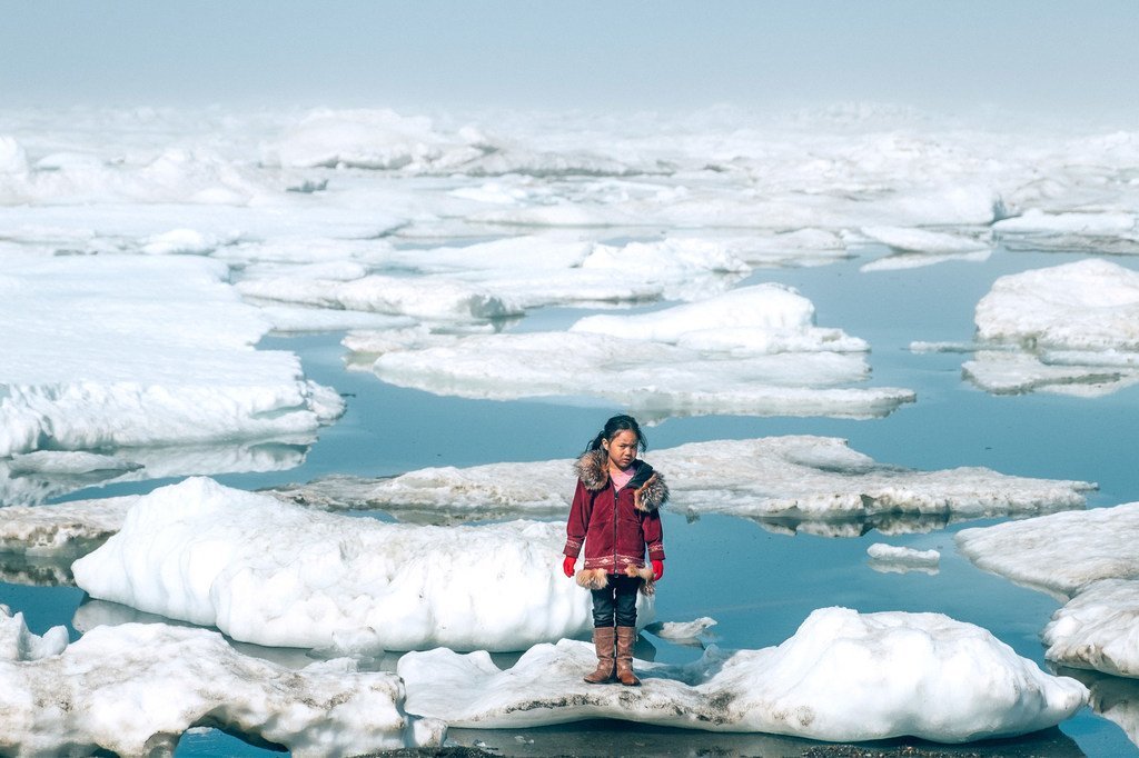 Une jeune fille de la communauté Iñupiat sur une banquise sur une rive de l'océan Arctique à Barrow, en Alaska. La fonte anormale des glaces de l'Arctique est l'un des nombreux effets du réchauffement climatique qui a de graves répercussions