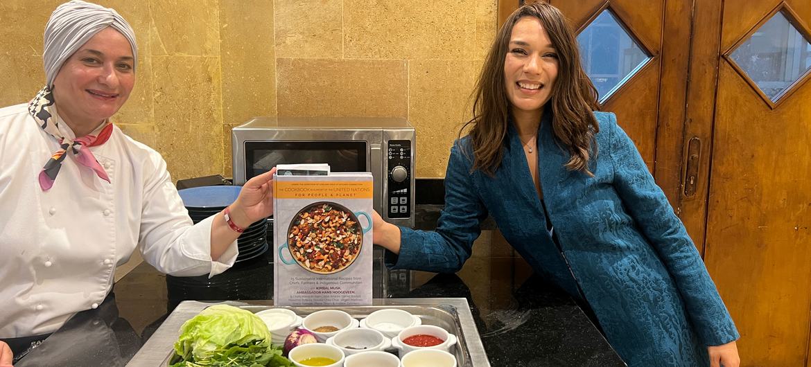 L’ambassadrice de bonne volonté du Programme alimentaire mondial, la chef Manal Al Alem, et la fondatrice de Kitchen Connection, Earlene Cruz, tiennent le livre de cuisine En Soutien aux Nations Unies.
