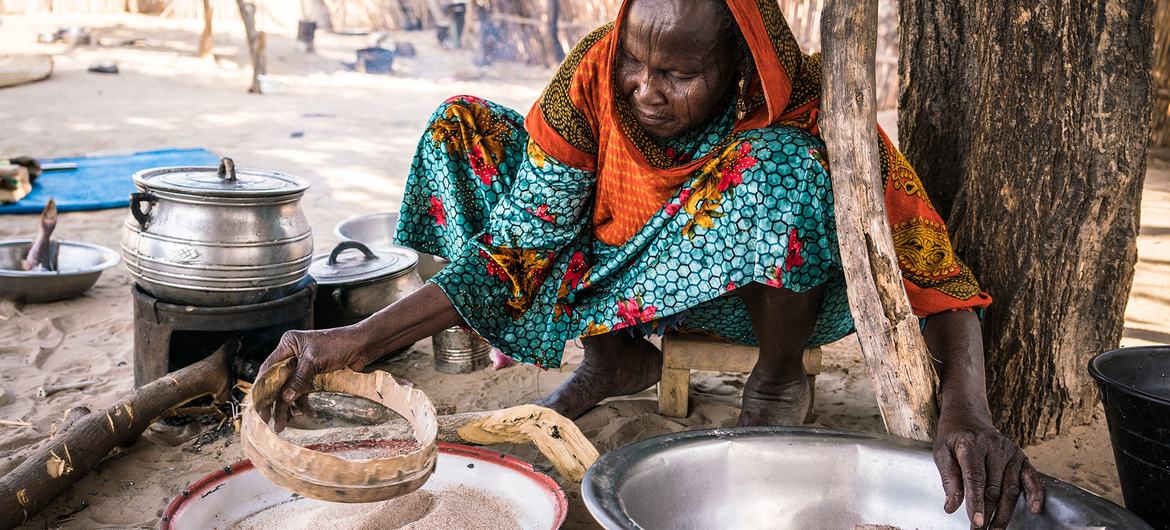 Une femme prépare un repas dans sa cuisine rurale au Tchad.
